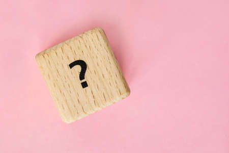 wooden cube with question mark on pink backgroundの写真素材