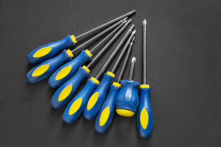 Set of crosshead screwdrivers with blue handles on black background