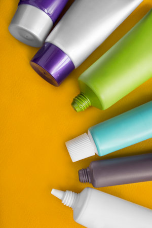 Set of blank plastic cosmetic tubes closeup on yellow backgroundの写真素材