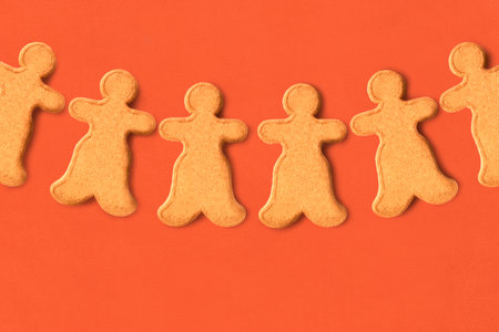 Some gingerbread men cookies on brown backgroundの写真素材