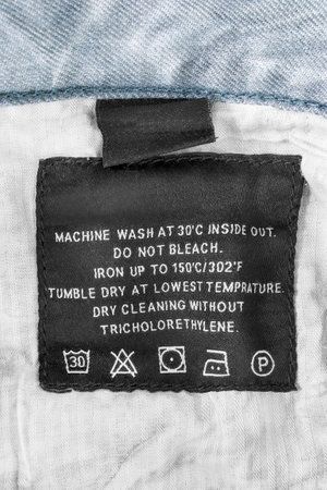 Washing instructions clothing label stitched on fabric closeupの写真素材