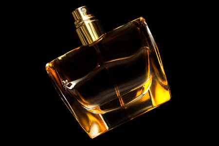 Golden glass perfumery bottle isolated on black backgroundの写真素材