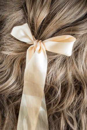 Ribbon bow tied on light brown hair closeupの写真素材