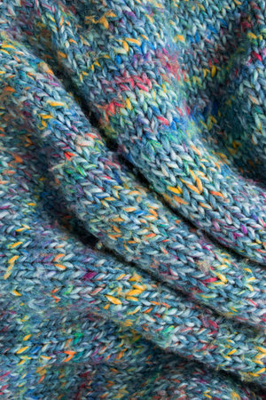 Colorful melange draped wool knit background closeup