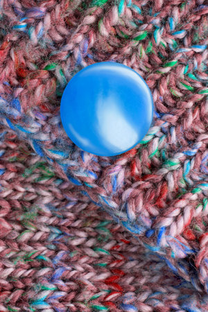 Blue button sewn on knit wool sweater closeup
