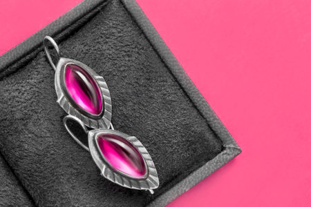 Vintage silver pink gems earrings in jewel box on pink backgroundの写真素材