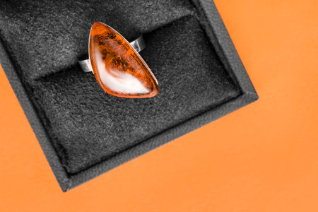 Large amber vintage ring in jewel box on orange color background