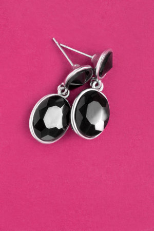Black onyx silver elegant earrings on magenta pink backgroundの写真素材