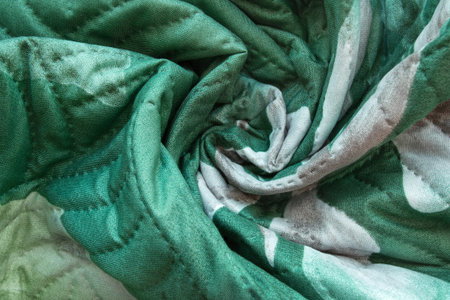 Draped green stitched fabric closeup as a background