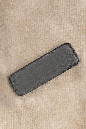 Blank clothes label patch on beige cotton fabric backgroundの写真素材