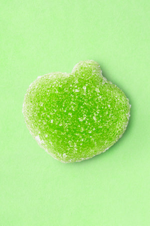 Green apple sugar candy on pastel green studio backgroundの写真素材