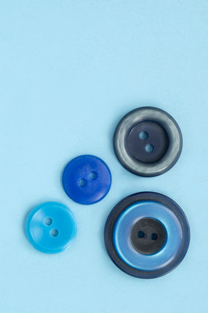 Four blue old clothes buttons on light blue studio backgroundの写真素材