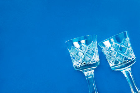 Two crystal shot wineglasses on blue studio backgroundの写真素材