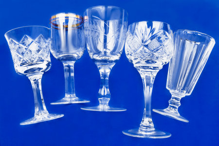 Five empty clean wineglasses on blue studio backgroundの写真素材