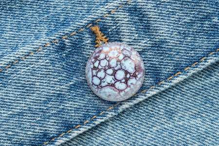 Clothes button on blue denim fabric closeupの写真素材