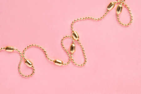 Golden chain necklace on pink studio backgroundの写真素材