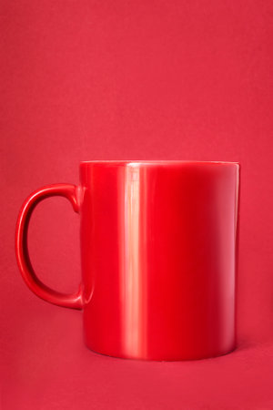 Red ceramic mug standing on red studio backgroundの写真素材