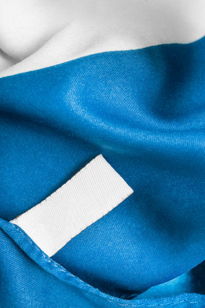 Blank clothes label on blue silk fabric backgroundの写真素材