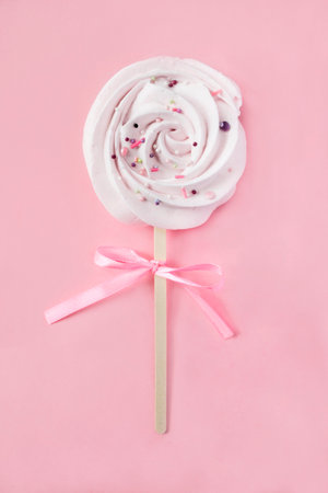 Marshmallow candy tied bow on pink studio backgroundの写真素材