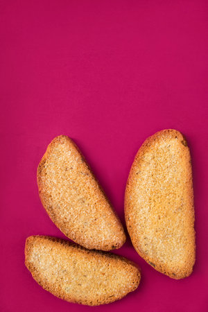 Three sugar cake rusks on fuchsia pink backgroundの写真素材