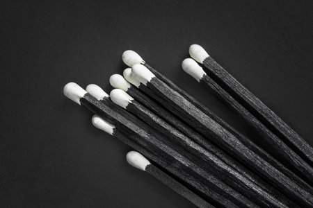 Some black sulfur matches on black studio backgroundの写真素材