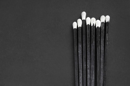 Some black sulfur matches on black studio backgroundの写真素材