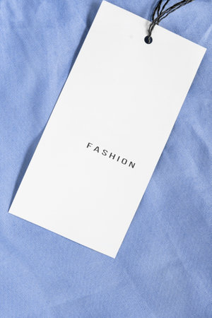 Clothes label says fashion on blue cotton fabric backtroundの写真素材