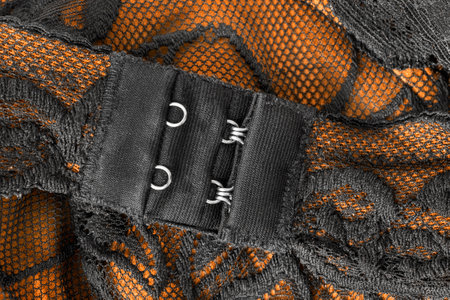 Yellow and black lacy bra clasp hooks fastener closeupの写真素材