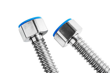 Two steel flexible water pipes nuts isolated on white background closeup
