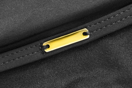 Blank golden name plate on black fabric background