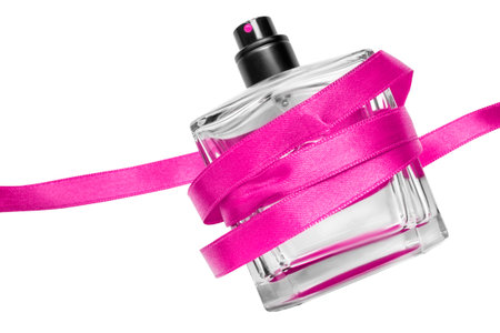 Perfume glass bottle tied with magenta pink ribbon isolated over whiteの写真素材
