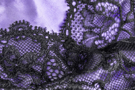 Black lace on purple satin fabric lingerie details closeup as a backgroundの写真素材