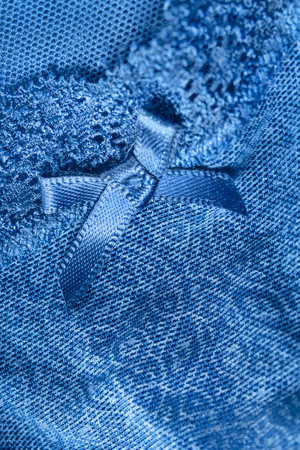 Blue fishnet lacy lingerie details with a bow closeup as a backgroundの写真素材