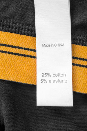 Fabric composition clothes label says made in China on black and yellow fabric closeupの写真素材