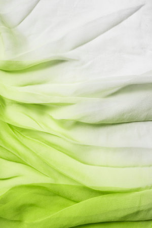 White and green ombre color silk draped fabric as a backgroundの写真素材