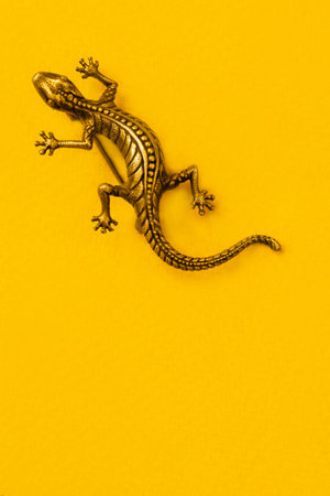 Vintage golden lizard brooch on yellow studio backgroundの写真素材