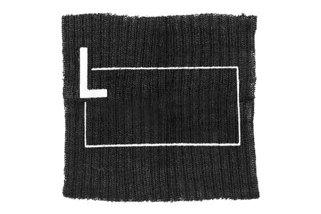 Black knit fabric patch with size L print isolated on white background