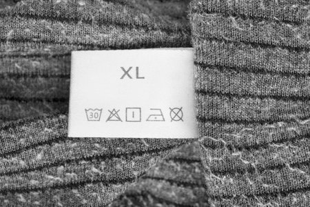 Size XL washing instructions clothes label on knit gray fabric closeupの写真素材