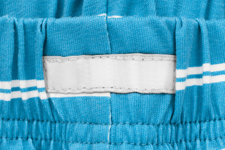 Blank patch clothes label stitched on blue knit fabric closeupの写真素材