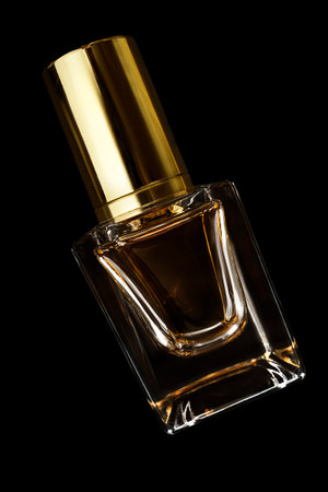 Transparent glass perfume bottle with golden lid isolated on black backgroundの写真素材