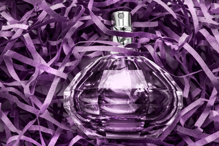 Crystal perfume spray bottle lying in purple shredded filling paperの写真素材