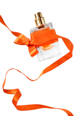 Perfume spray bottle orange color ribbon tied bow isolated on white backgroundの写真素材