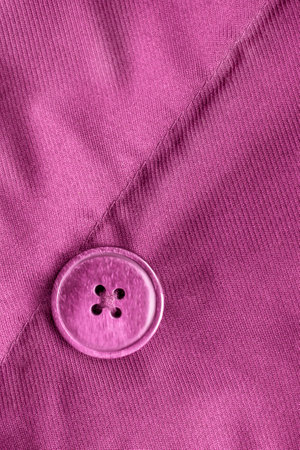 Pink clothes jacket button sewn on pink fabric background closeupの写真素材