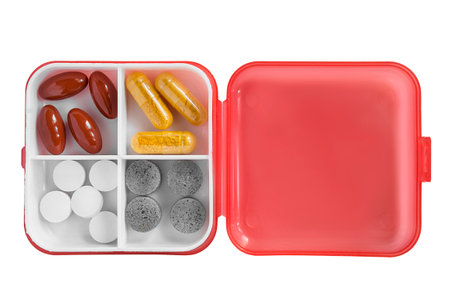 Open plastic pillbox with pills inside isolated on white backgroundの写真素材