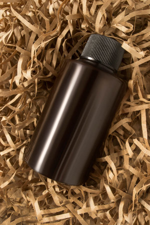 Brown blank body wash bottle lying on craft shredded packaging paper
