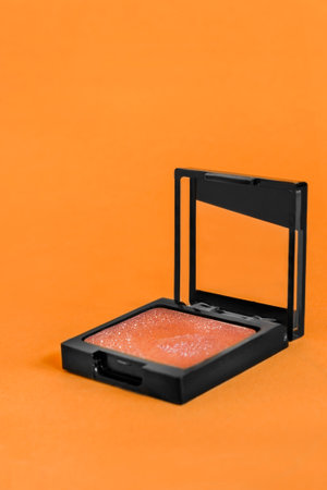 Orange color eyeshadows glitter box on orange studio backgroundの写真素材