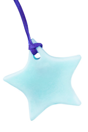 Light blue plastic five-pointed star trinket on a lace isolated on white backgroundの写真素材