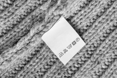 Care instructions clothes label on gray wool knit fabric background closeupの写真素材