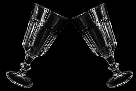 Two clinking vintage crystal clean wineglasses isolated on black backgroundの写真素材