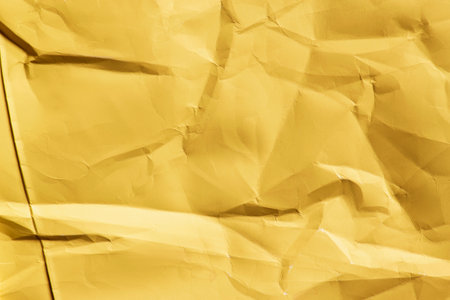Yellow crumpled blank wrapping paper texture closeup as a backgroundの写真素材